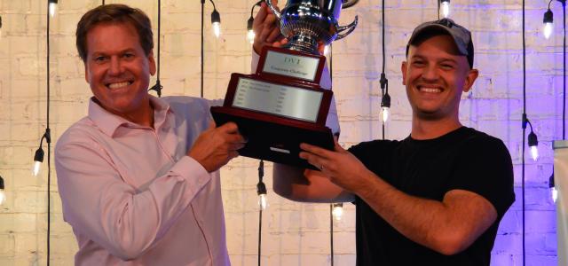 The 2022 Corporate Ping Pong Champions, Tom & Corey Hammerton from OSF, hoist the championship cup above their heads.